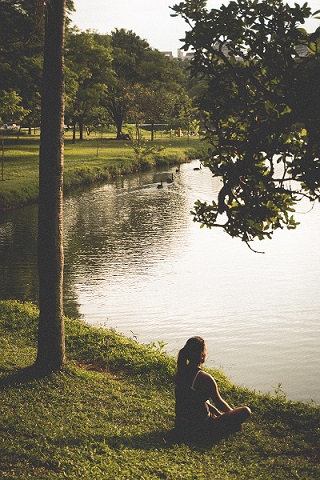 Woman sitting by lake